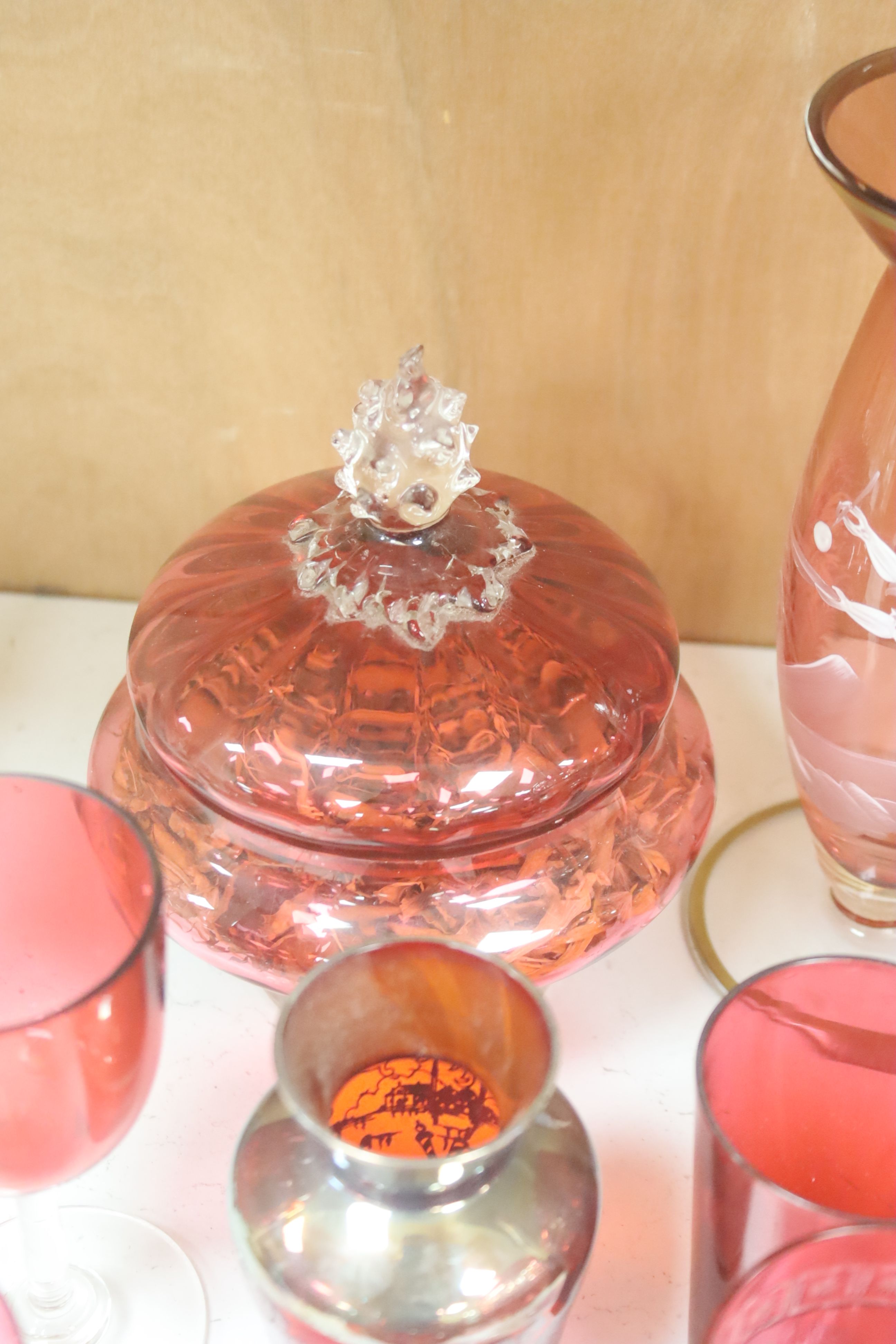 A collection of cranberry and ruby glassware including a 'Mary Gregory' vase